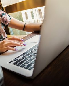 A woman types on a laptop. She is beginning online therapy in San Diego, CA with Headway Therapy.