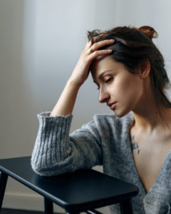 A woman looks distraught. She is looking forward to starting grief counseling in San Diego, CA with Headway Therapy.