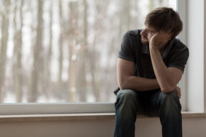 A man looks sad. He is looking forward to starting depression counseling in Encinitas, CA with Headway Therapy 92024. 