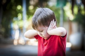 A child covers his ears. He could benefit from starting child therapy in San Diego, CA or online therapy for children in California.