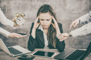 A woman sits at a table. This demonstrates aspects of burn out and therapy for high achievers in San Diego, CA. 